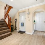 Spacious hallway with staircase and wooden flooring.