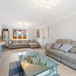 Modern living room with grey sofas and glass table.