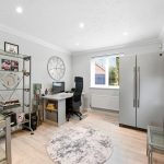Modern home office with chair, desk, and shelf