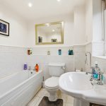 Modern bathroom with bathtub, sink, and toilet.