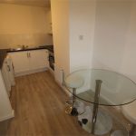 Modern kitchen with round glass dining table.