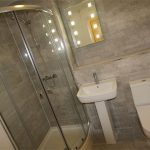 Modern bathroom with shower, sink, and toilet.