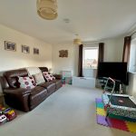Living room with sofa, TV, and children's toys