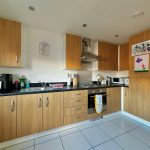 Modern kitchen with wooden cabinets and appliances.
