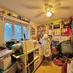 Cluttered craft room with sewing supplies and storage.