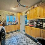Spacious kitchen with wooden cabinets and tiled floor.
