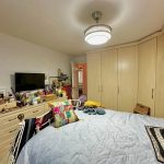 Cosy bedroom with TV and colourful cushions.