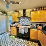 Cosy kitchen with black stove and wooden cabinets.