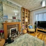 Cosy living room with fireplace and large TV.