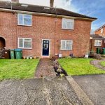 Brick house with green bins and front garden.
